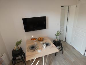 a dining room table with a television on a wall at Le P'tit Torceen proche de Dieppe in Torcy-le-Petit +27 photos
