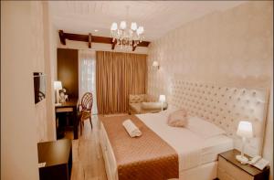 a bedroom with a large bed and a desk at Green House Hotel & Restaurant in Tirana