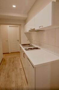 a kitchen with white cabinets and a white counter top at Green House Hotel & Restaurant in Tirana