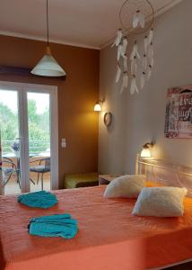 a bedroom with a large orange bed with two towels on it at Sausan Hotel in Sidari