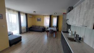 cocina y sala de estar con sofá y mesa en APARTAMENT JAN-54 Krynica Morska, en Krynica Morska