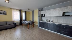 a living room with a table and a kitchen at APARTAMENT JAN-54 Krynica Morska in Krynica Morska +13 photos