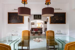 a dining room with a glass table and chairs at Domus Orestea Luxury Suites in Palermo