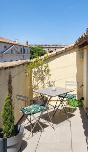 een patio met een tafel en stoelen op een balkon bij La Dolce Vita Nîmoise Terrasse 100 m des Arènes in Nîmes