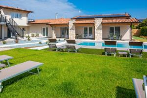 a villa with a swimming pool and green lawn at Corte Rocchetti Suite in Lazise