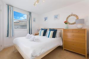 a bedroom with a bed with a window and a dresser at White Surf Cottage in St Ives