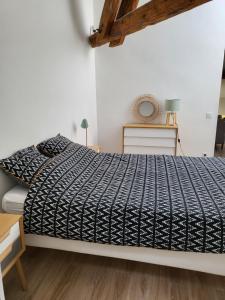 una camera da letto con un letto con un piumone nero di La Dolce Vita Nîmoise Terrasse 100 m des Arènes a Nîmes