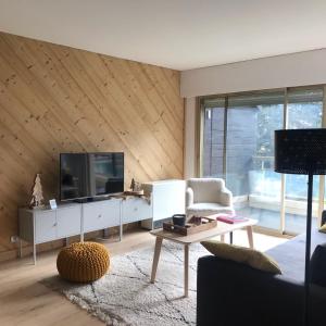 a living room with a television and a couch at Appartement centre Barcelonnette in Barcelonnette