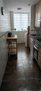 a kitchen with a sink and a table in it at Apto Pirigolf & Pool Margas, Sabiñánigo in Sabiñánigo