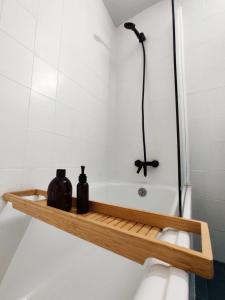 a bathroom with a bathtub with two bottles on a shelf at Ca la Torreta in Torredembarra +36 photos