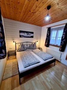 a bedroom with a bed and a wooden ceiling at The Little Pool House in Wagrain