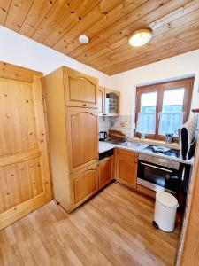 a kitchen with wooden cabinets and a stove top oven at The Little Pool House in Wagrain