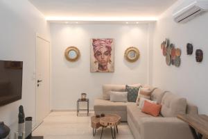 a living room with a couch and paintings on the wall at G&J Deluxe Apt II in Zakynthos