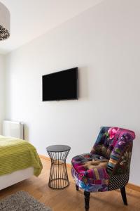 Pokój z krzesłem i telewizorem na ścianie w obiekcie Villa Balladyna w mieście Gdynia