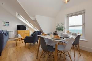 een eetkamer en woonkamer met een tafel en stoelen bij Little Gem in St Ives