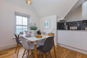 een keuken en eetkamer met een tafel en stoelen bij Little Gem in St Ives