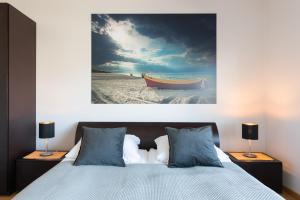 a bedroom with a bed and a painting of a boat at Villa Balladyna in Gdynia