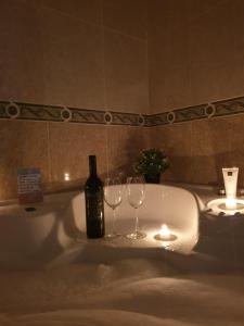 a bottle of wine and two wine glasses in a bath tub at Casa Maria in Olivenza +57 photos
