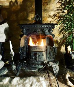 una antigua chimenea de piedra con fuego. en Beautiful House in Algarve Portugal, en Mexilhoeira Grande