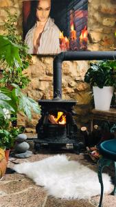 a stone wall with a fireplace and a painting of a woman at Beautiful House in Algarve Portugal in Mexilhoeira Grande