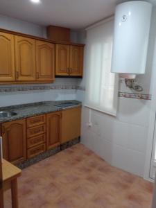 - une cuisine avec des placards en bois et un évier dans l'établissement Acera del Rio, à Cordoue