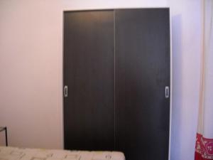 ein schwarzer Schrank in einem Zimmer mit einem Bett in der Unterkunft Casa Emilia in Almería