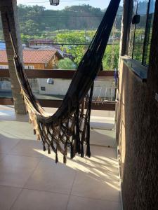a hammock on a balcony with a view of a city at Casa 1 Encanto dos Mares in Itapema