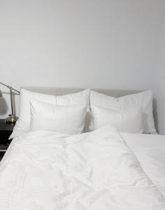 a white bed with white sheets and pillows at The Urban Penthouse in Oslo