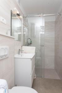 ŽrnovnicaにあるApartman MARELのシャワーと洗面台を備えた白いバスルーム