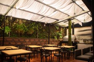 a patio area with tables, chairs and umbrellas at Ivy Hostel in Medellín