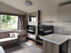 a living room with a couch and a television at Vault 21 in Millom