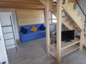 ein Wohnzimmer mit einem blauen Sofa und einem TV in der Unterkunft GM HOUSE in Gravedona