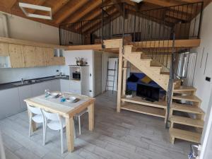 ein Wohnzimmer mit einem Tisch und einem Loft in der Unterkunft GM HOUSE in Gravedona