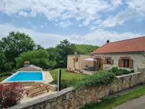 una casa con piscina junto a una pared de piedra en Holiday house Green Dream, en Obrovac
