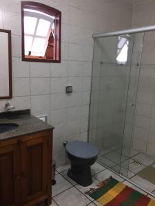 a bathroom with a blue toilet and a glass shower at Casa do Éden in Paraty +34 photos