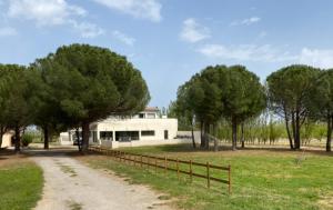 CastelnouにあるHôtel Restaurant Mas del Gallの木の木と柵のある畑の家