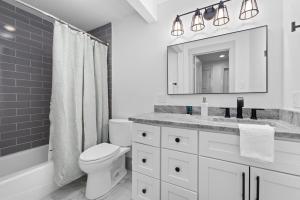 a bathroom with a toilet and a sink and a mirror at New Mountain Retreat with Hot Tub & Putting Green in Heber City +19 photos