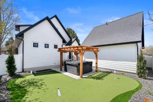 un patio trasero con una pérgola frente a una casa en New Mountain Retreat with Hot Tub & Putting Green, en Heber City