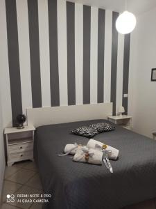 1 dormitorio con 1 cama con rayas blancas y negras en Sicilia bedda, en Isola delle Femmine