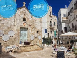 un edificio de piedra con dos signos azules. en Monopoli Casa Vacanze, en Monopoli