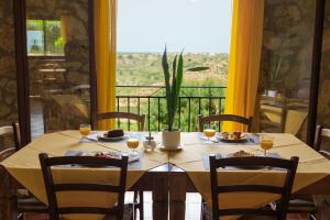 a dining table with a view of a balcony at Casale Ginisara in Castellammare del Golfo