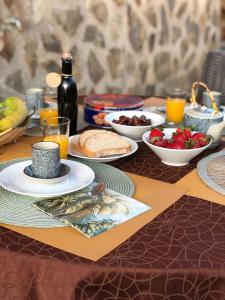 una mesa cubierta con platos de comida y tazones de fruta en Alojamientos El Chorro, en Los Navalucillos