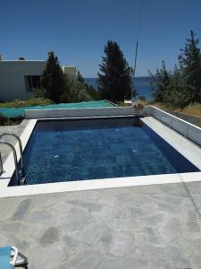 a swimming pool with a view of the ocean at Plakia Beach Apartments in Pefki