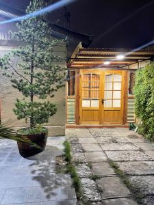a house with a wooden door and a tree at Manso de Velasco in Rancagua