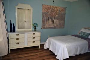 Historic Sebring Downtown Home في سيبرينغ: غرفة نوم مع سرير وخزانة مع مرآة