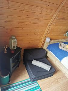 una habitación con una cama y una mesa en una cabaña en Cosy Forest Pod with Wood Fired Hot Tub & Fire Pit, en Hambleton