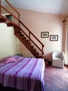 a bedroom with a bed and a spiral staircase at La casa in campagna in Aragona