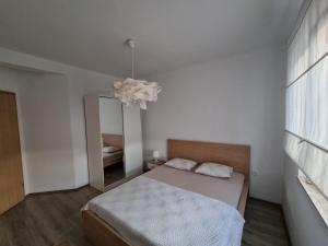 1 dormitorio con espejo y 1 cama. en Vila Regina, en Pašman