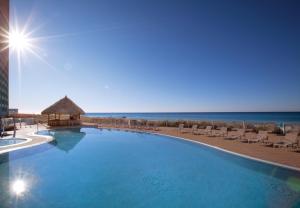 a large swimming pool with chairs and the ocean at Club Wyndham Panama City Beach in Panama City Beach