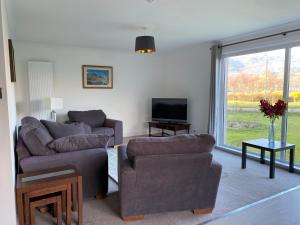 a living room with two couches and a television at Lyn leven cottages in Ballachulish